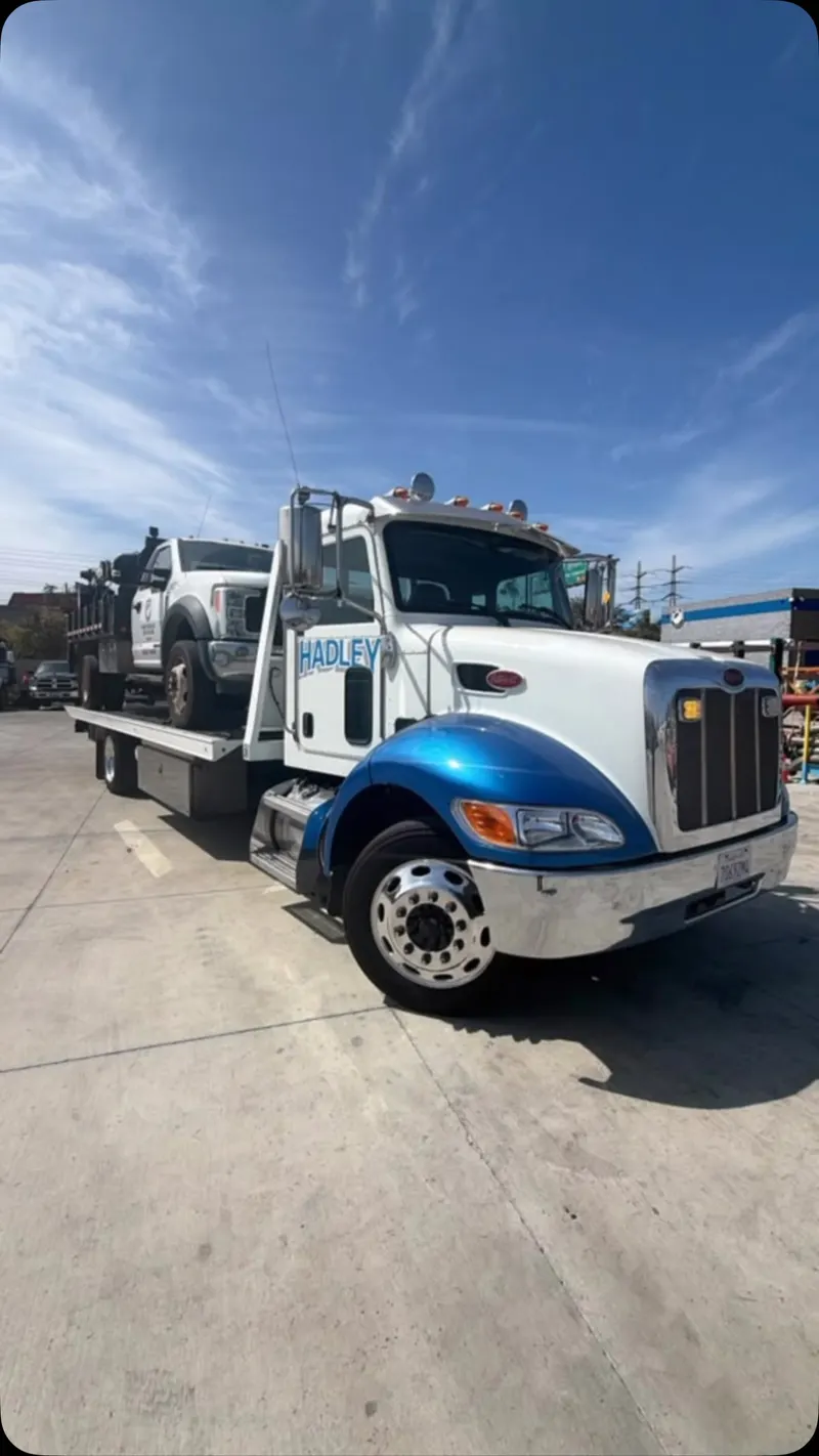 Hadley flatbed carrying a work truck in a video