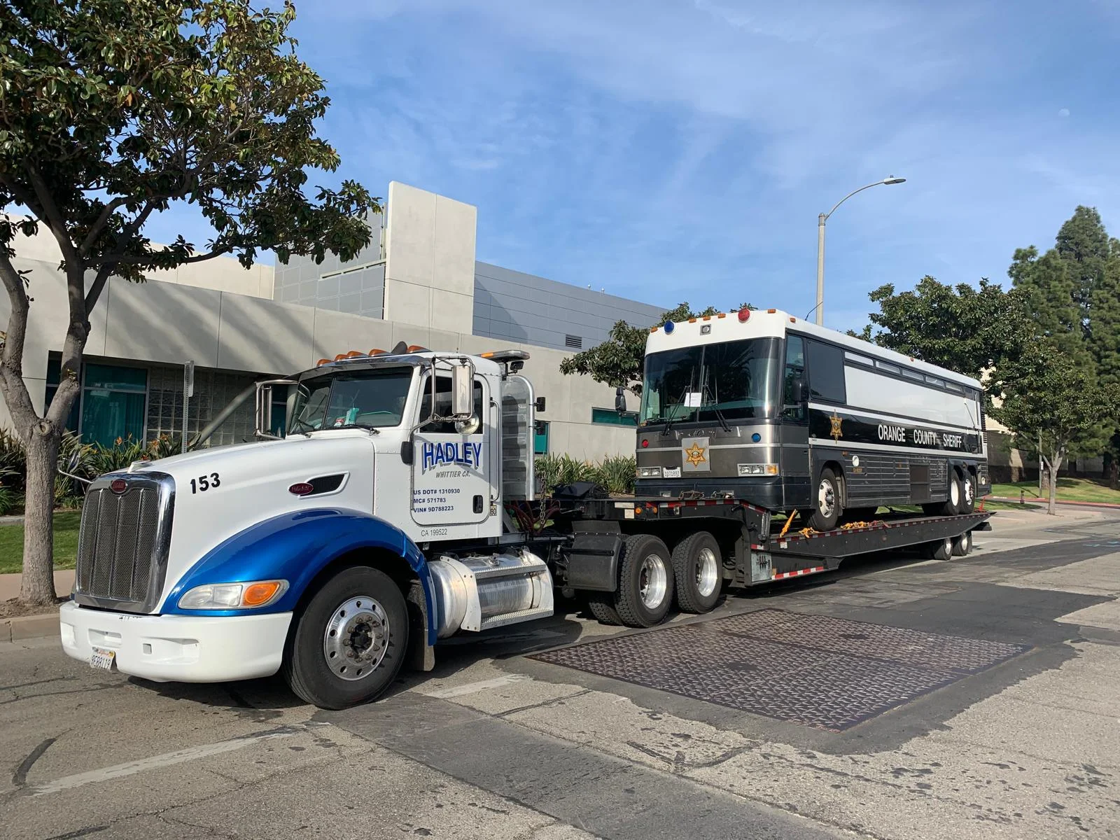 Hadley tractor 153 transporting an Orange County Sheriff bus on a trailer