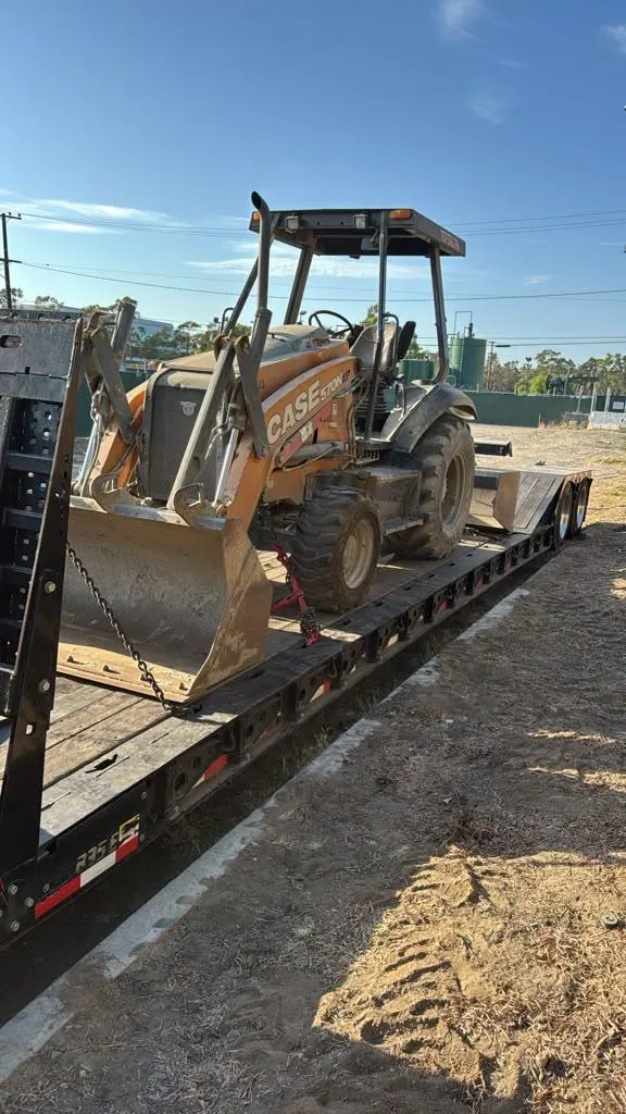 CASE backhoe secured to a Hadley transport trailer