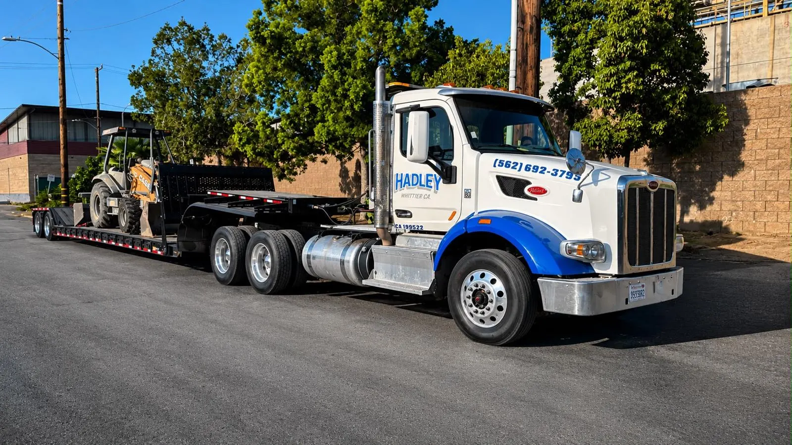 Hadley tractor and trailer transporting construction equipment