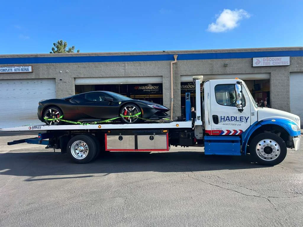 Black Ferrari secured with green straps on Hadley flatbed 107