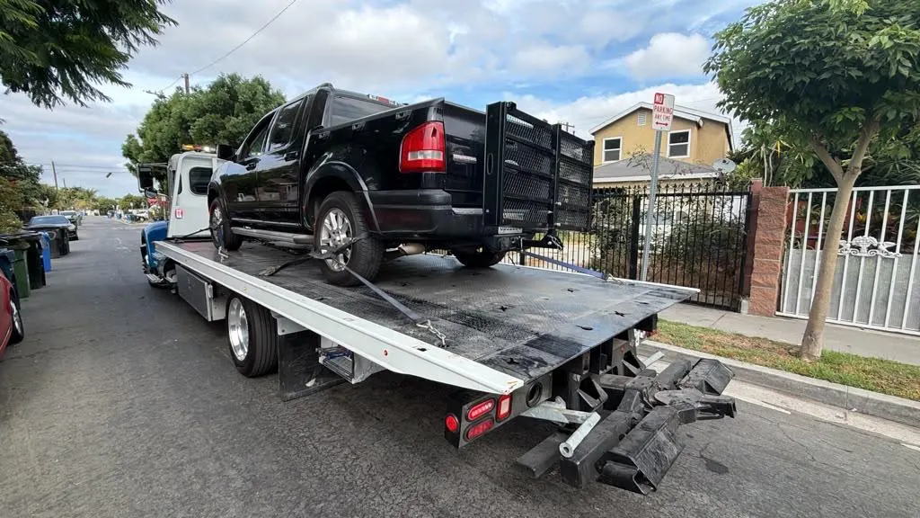 Black pickup secured on a Hadley flatbed